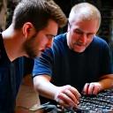 Two audio technicians collaborating on equipment setup